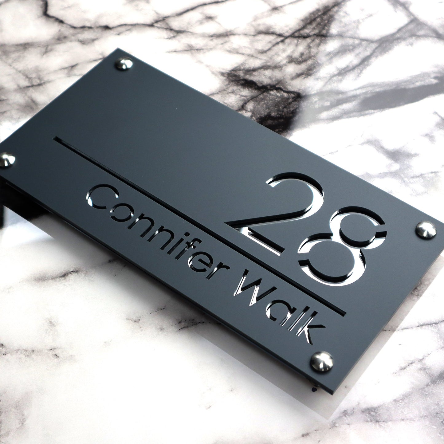 Custom British house number sign made from laser-cut acrylic with a matte gray and silvery mirror finish.