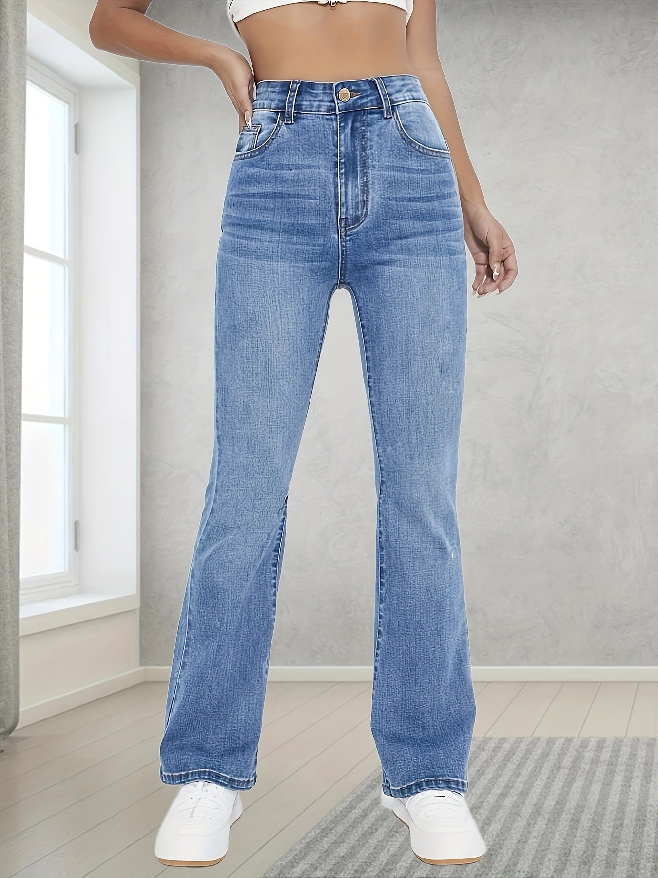 Washed blue flare leg jeans with stretch, slant pockets, and bell bottom design for women.