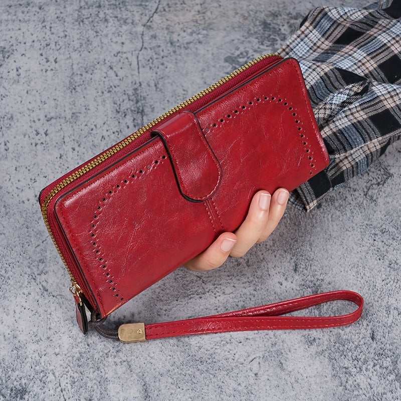 Black faux leather long clutch wallet with wristlet, ID card compartment, button closure, and edge paint. Dry clean only.