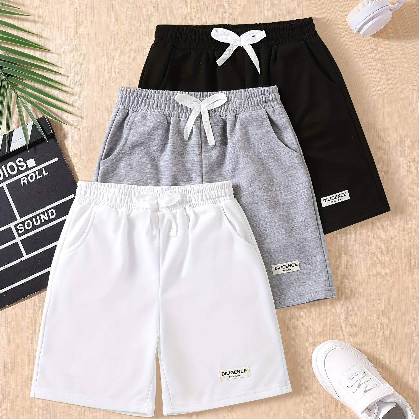 Three-pack of boys' summer shorts in solid colors, made from polyester knit with slight stretch, featuring elastic drawstring waist and regular fit. Ideal for sports and leisure activities