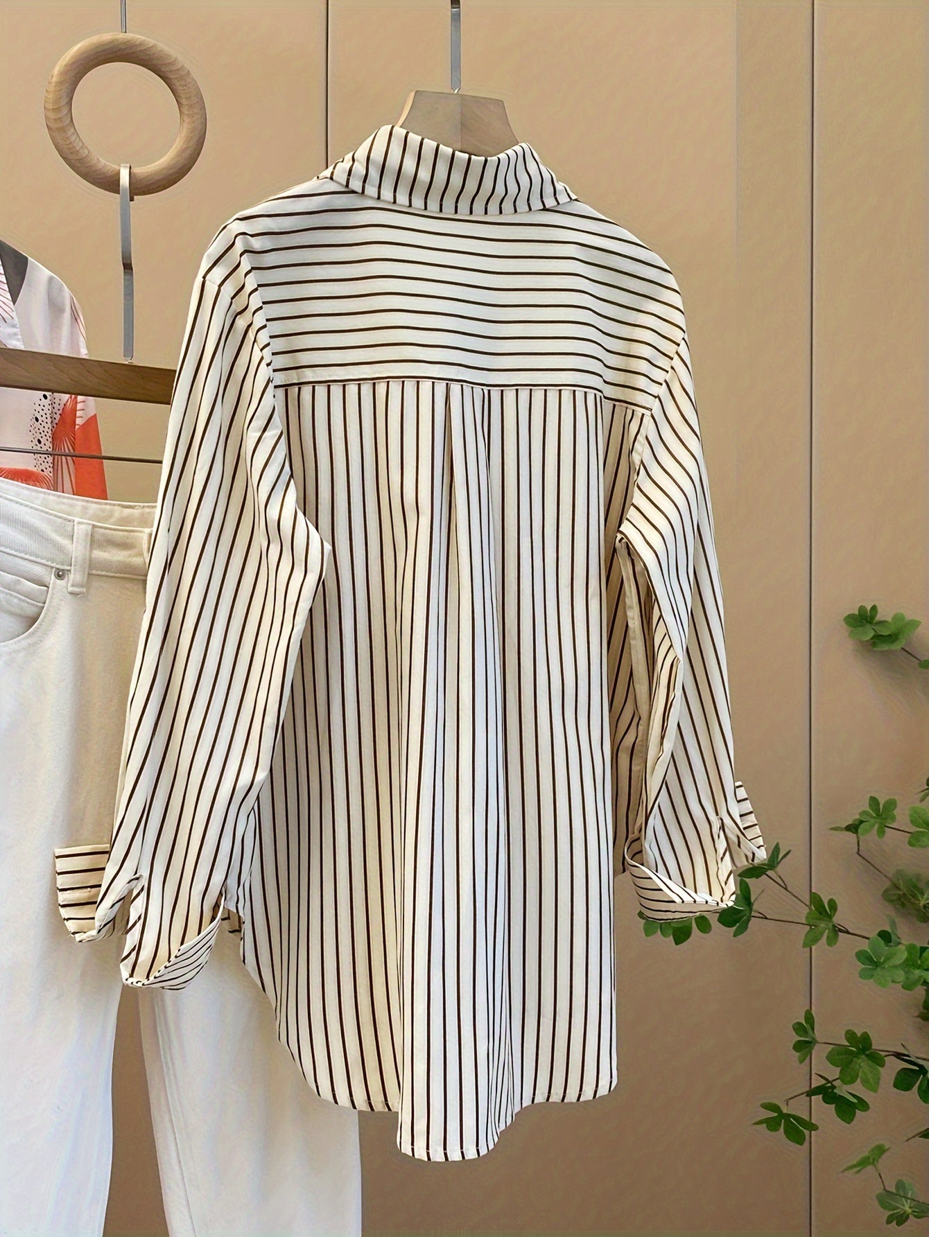 Striped blend shirt for women, with loose fit and ruffled hem detail. French-inspired chic look, perfect for casual wear.