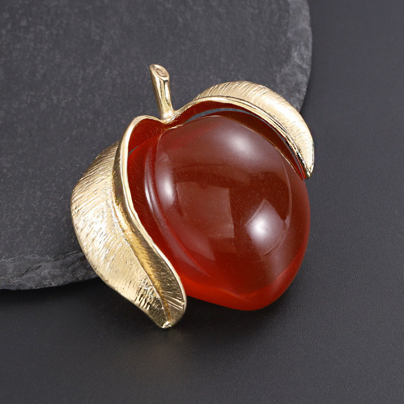 Vintage-inspired enamel brooch in a sophisticated peach design, featuring a high-end transparent finish. This fashionable fruit-shaped pin is a stylish accessory for clothing and suits.