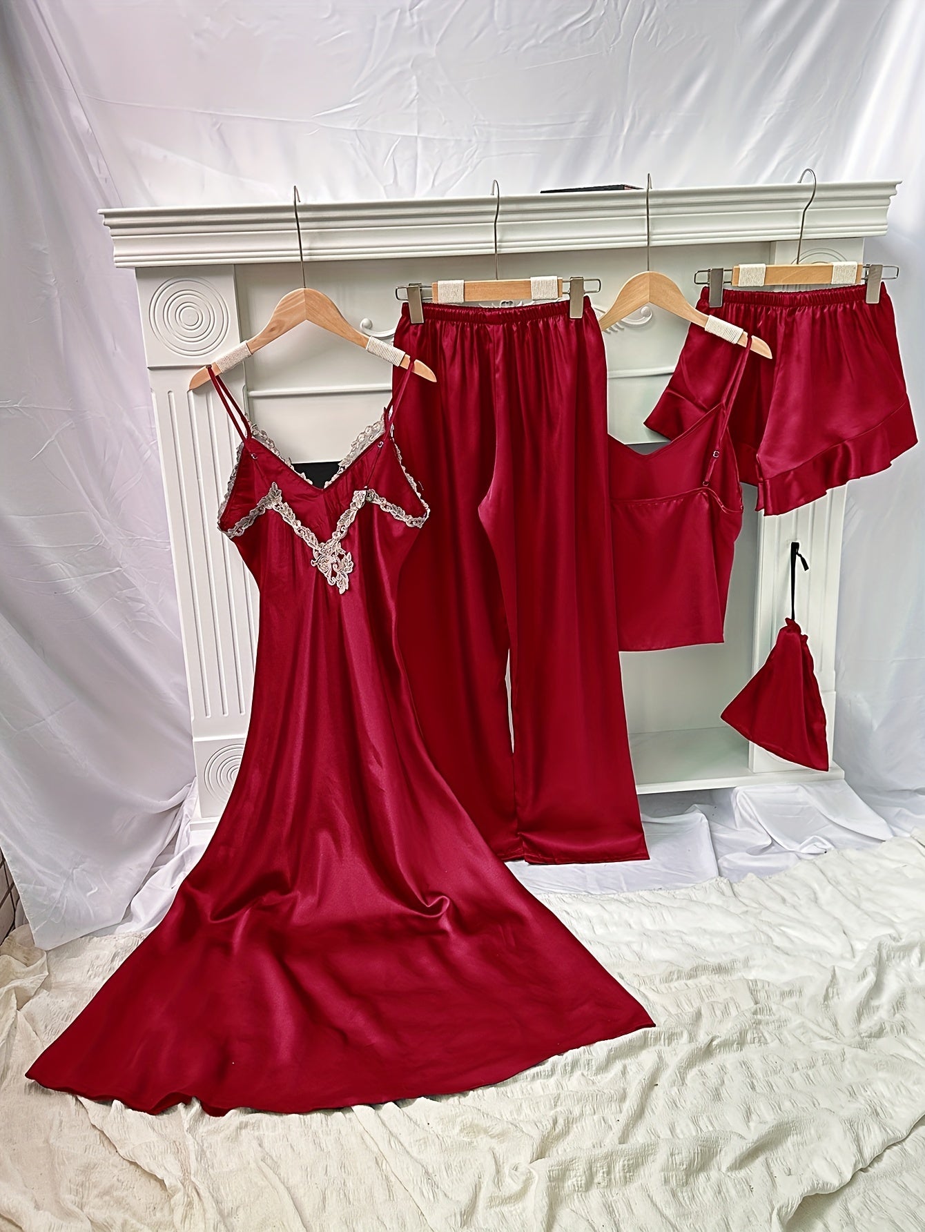 Set of 5 elegant pajamas for women with V-neck and lace detail. Includes camisole, shorts, pants, and storage bag. Made of 100% polyester all-season fabric.