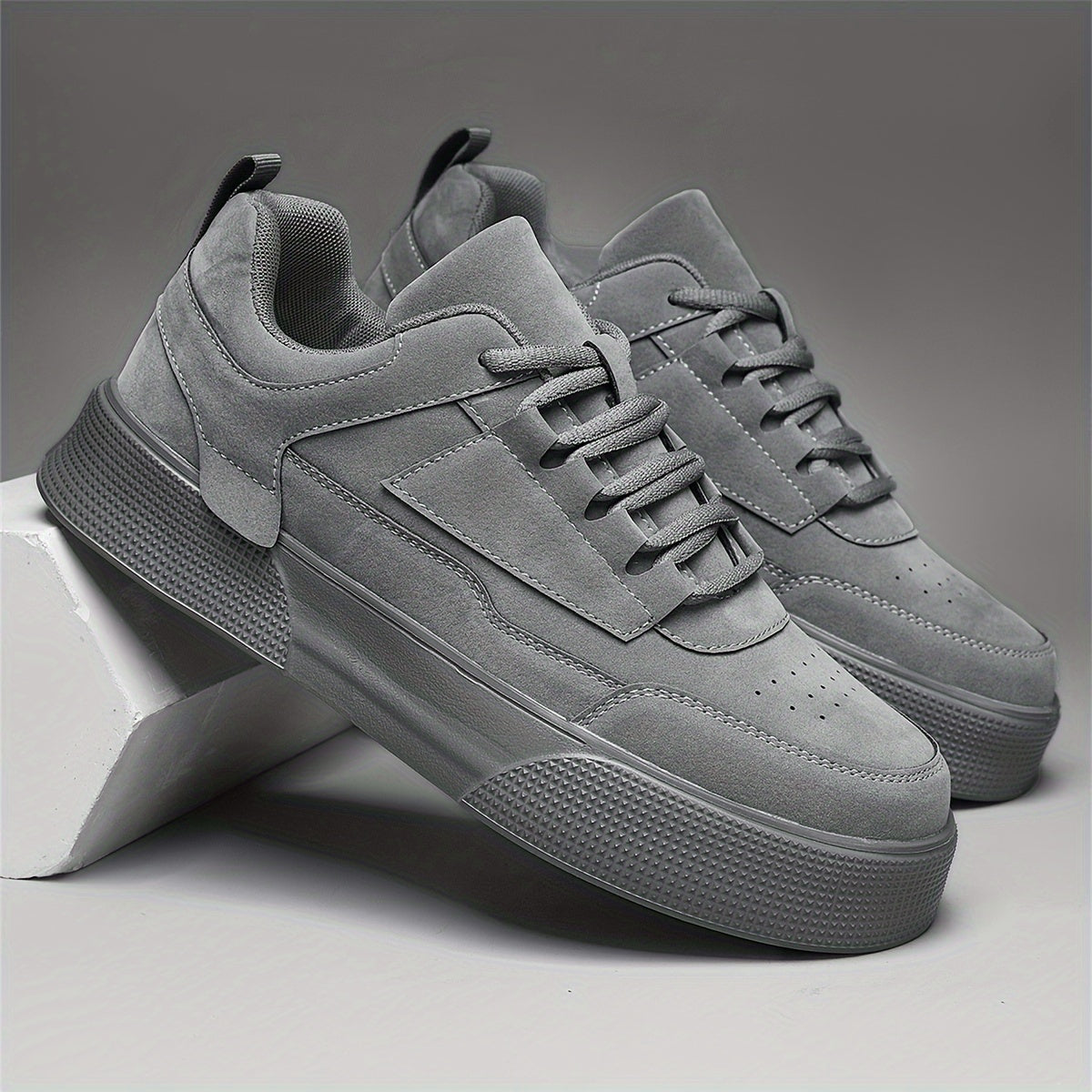 Men's gray low-top skate shoes with a thick sole, lace-up design, round toe, and height increase for casual wear. Features a modern design and durable EVA sole.