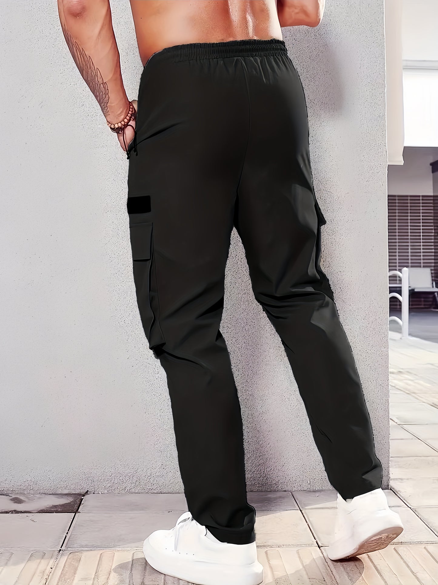 Men's casual cargo pants made of 100% polyester with an elastic waist, multi-pocket design, regular length, and loose fit for spring and fall wear.