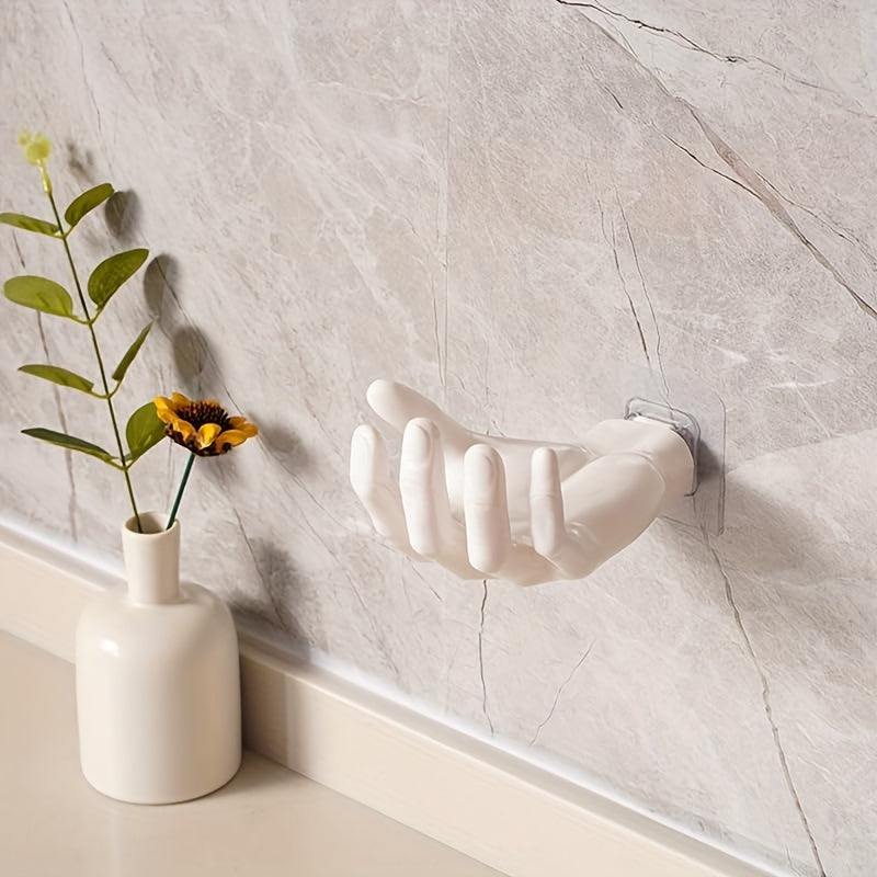 Palm-shaped adhesive wall hook for strong, no-drill, traceless storage of keys and headphones at home.