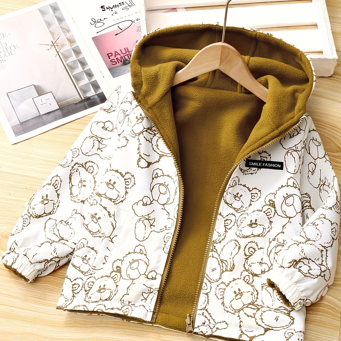 Kids' reversible hooded jacket featuring a cute bear pattern, fleece-lined for warmth in fall/winter. Made of polyester with pockets.