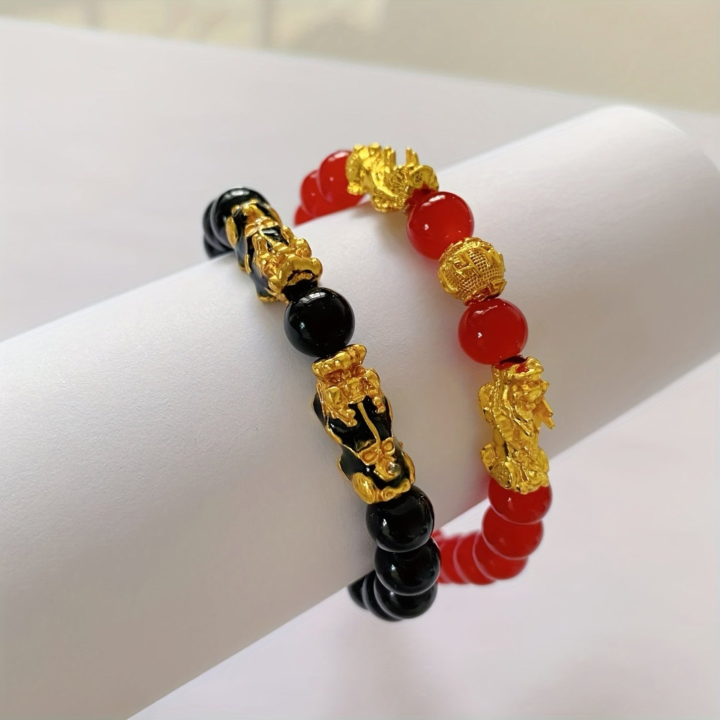 Two Pixiu bracelets, one in red antique style, offering a safe and lucky accessory. This classic, luxurious piece symbolizes prosperity and is beautifully crafted with shiny, artificial jewels. Perfect for gifting to girlfriends, sisters, or mothers to