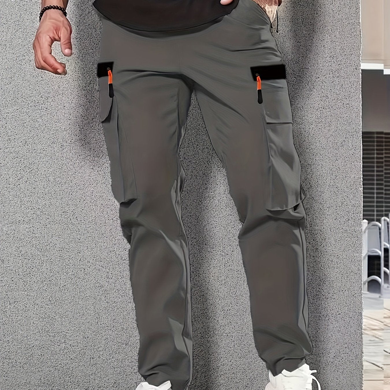 Men's casual cargo pants made of solid color polyester, feature a regular fit, multiple pockets, and straight-leg design for sports and leisure activities all year round.