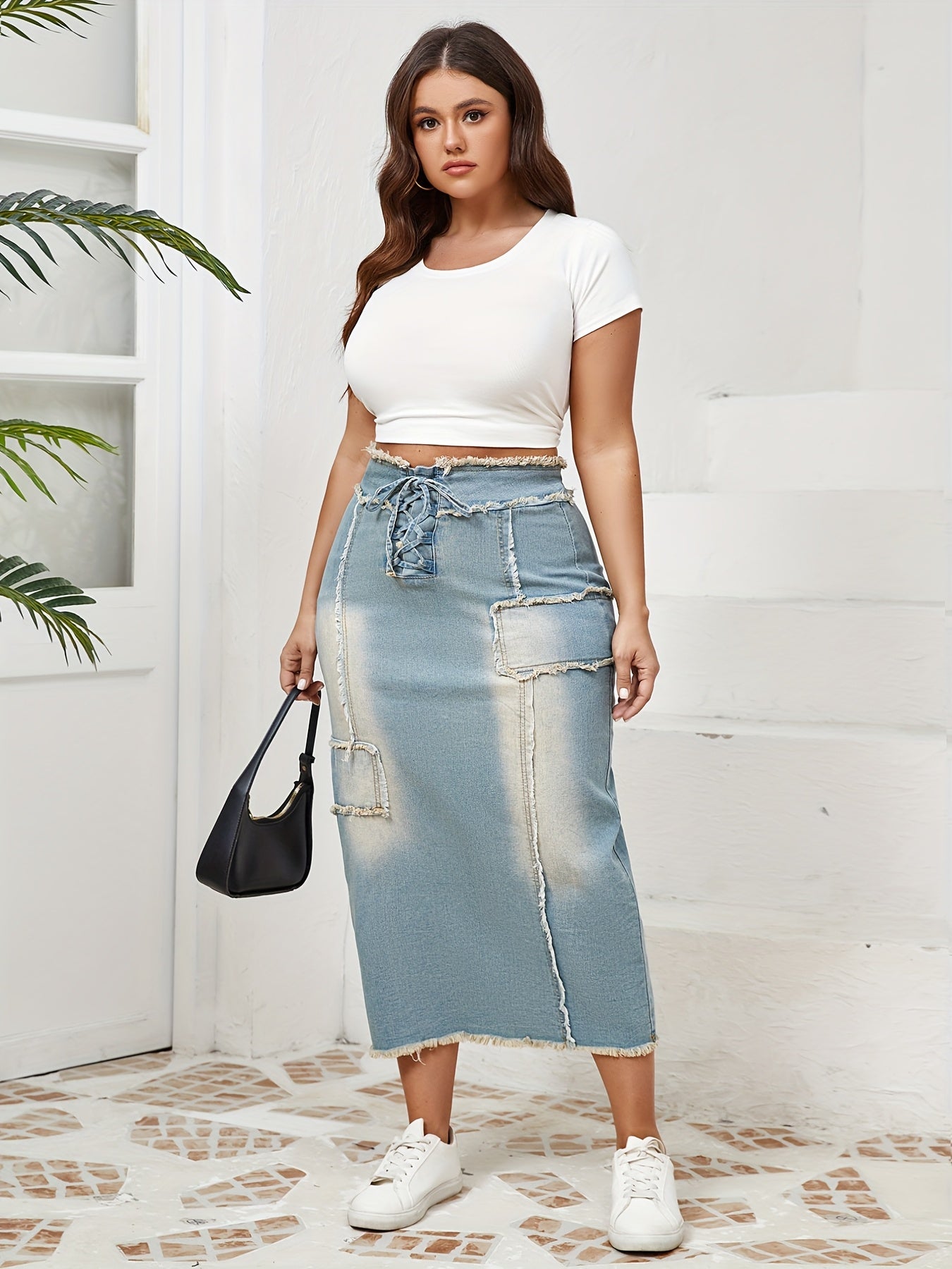 Women's high-waist denim midi skirt with frayed hem and lace-up details in a gradient light blue to dark wash. Raw edge detailing, versatile for spring/summer/fall.