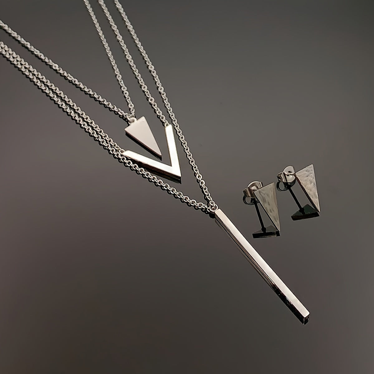 Three pieces of Stainless Steel Long Strip V-shaped Geometric Pendant with a Multi-layer Necklace and Triangle Earrings. Perfect as a Birthday or Holiday Gift, Clothing Decoration, or Party Accessories.