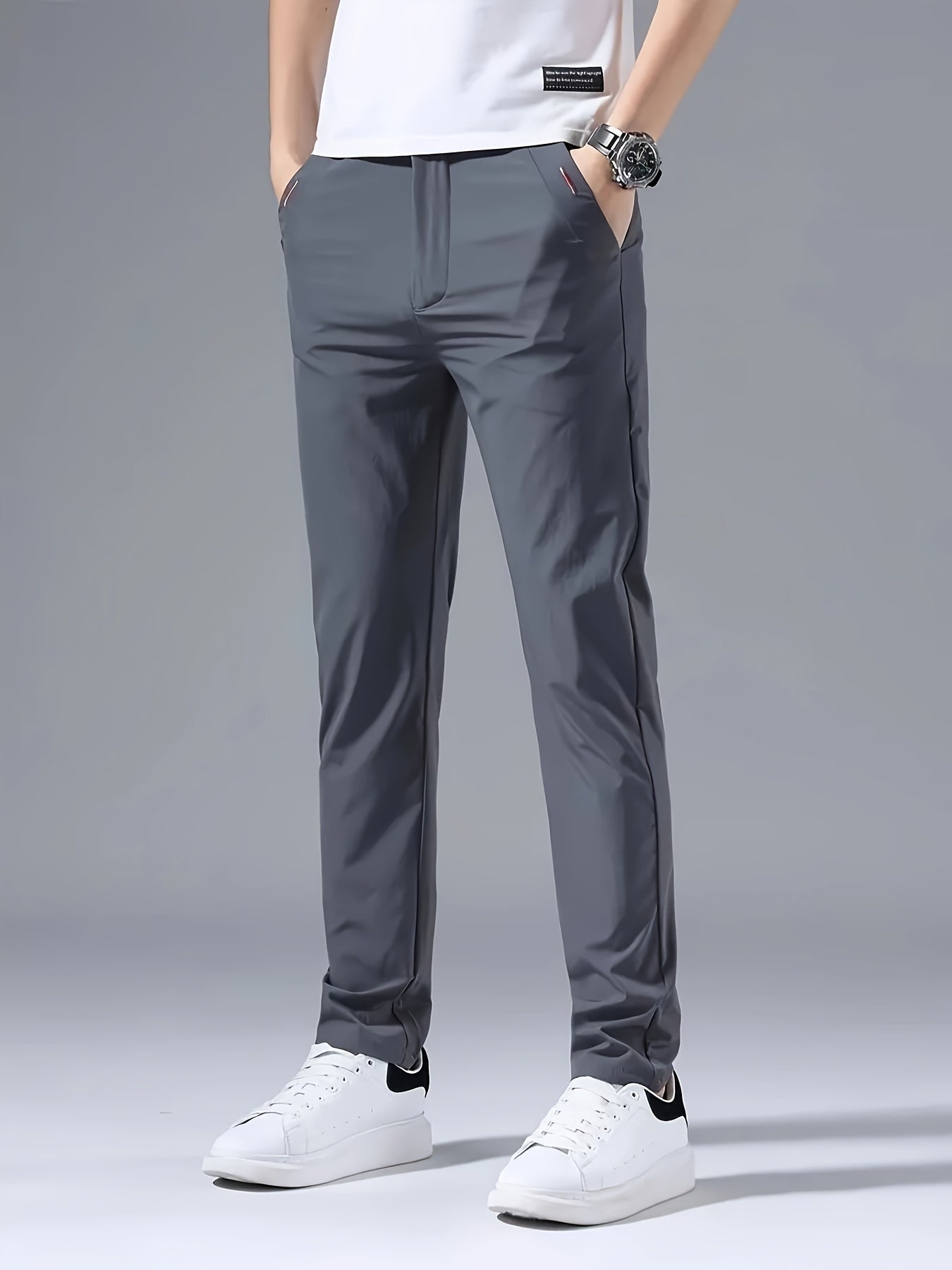 Men's slim fit casual pants made of breathable nylon fabric with pockets and embroidery. Suitable for outdoor and daily wear in a solid color basic style. Features zippered waist for