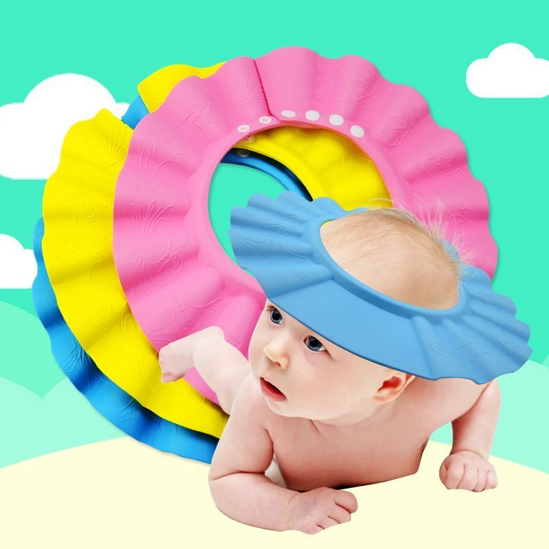 Adjustable baby shampoo cap in pink and yellow, made of soft polyester, protects eyes and ears during hair washing. Ideal for bathing and hair care.