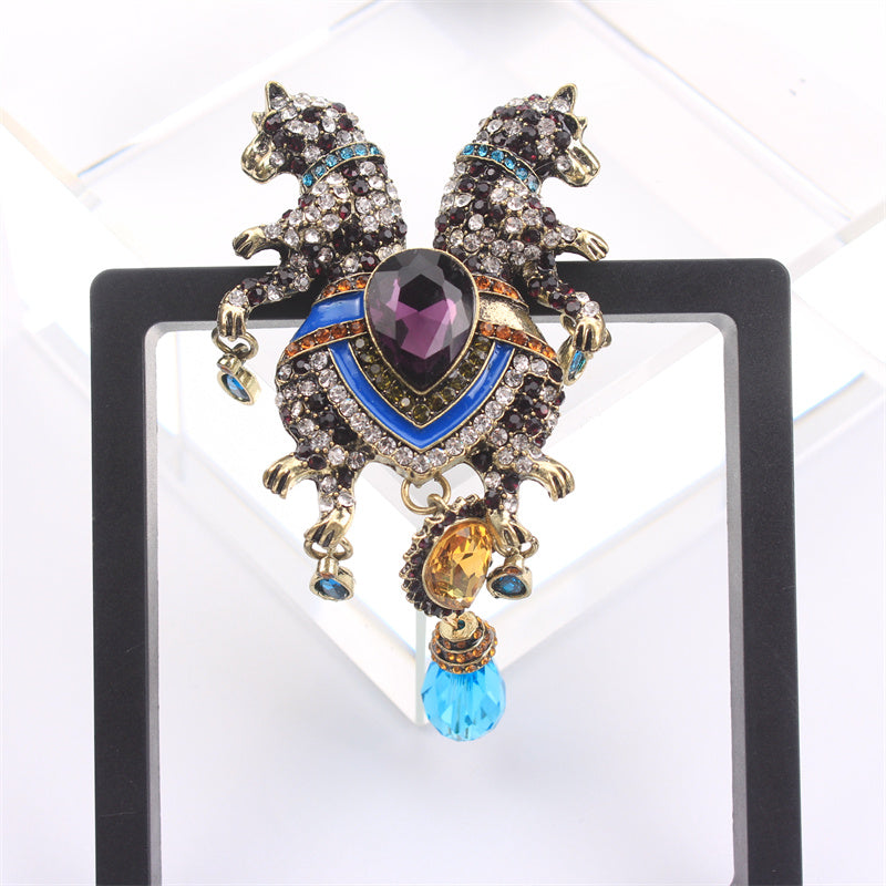 Luxurious and elegant, this animal brooch pin featuring a double-headed leopard with tassel is adorned with rhinestones. This novelty accessory has an irregular shape that enhances its charm. Perfect for adding a decorative touch to clothing, bags, and