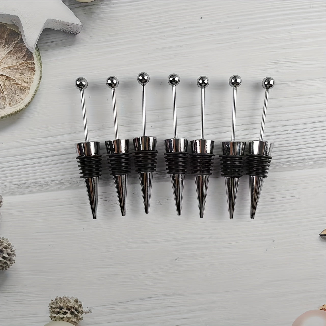 Set of 7/14/28 stainless steel wine stoppers for preserving red wine and champagne bottles. Essential bar accessories.