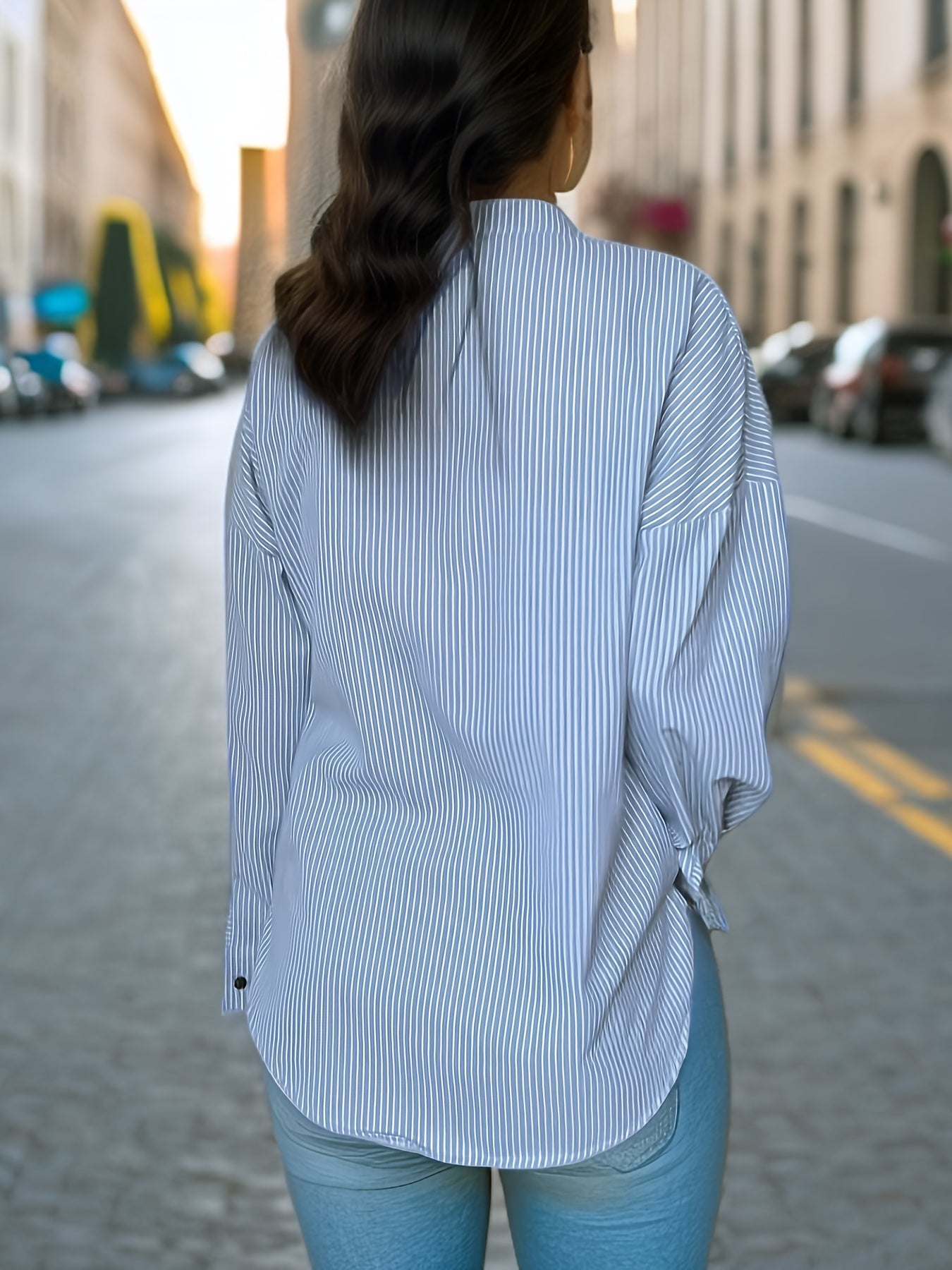 Women's striped shirt with drop shoulders, long sleeves, v-neck, and button closure.