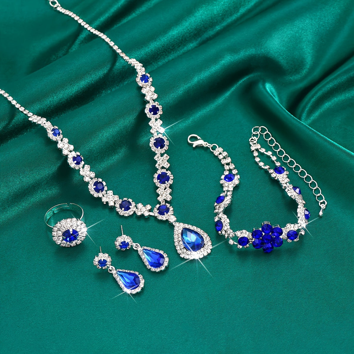 This jewelry set features a vintage 4-piece design with synthetic gemstones, a sexy tear-drop style, and a silver plated finish with rhinestones. Made from copper, this set is perfect for vacation and wedding events, and makes an ideal gift for