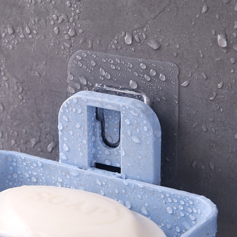 Wall-mounted soap holder with box drain for toiletries and shampoo.