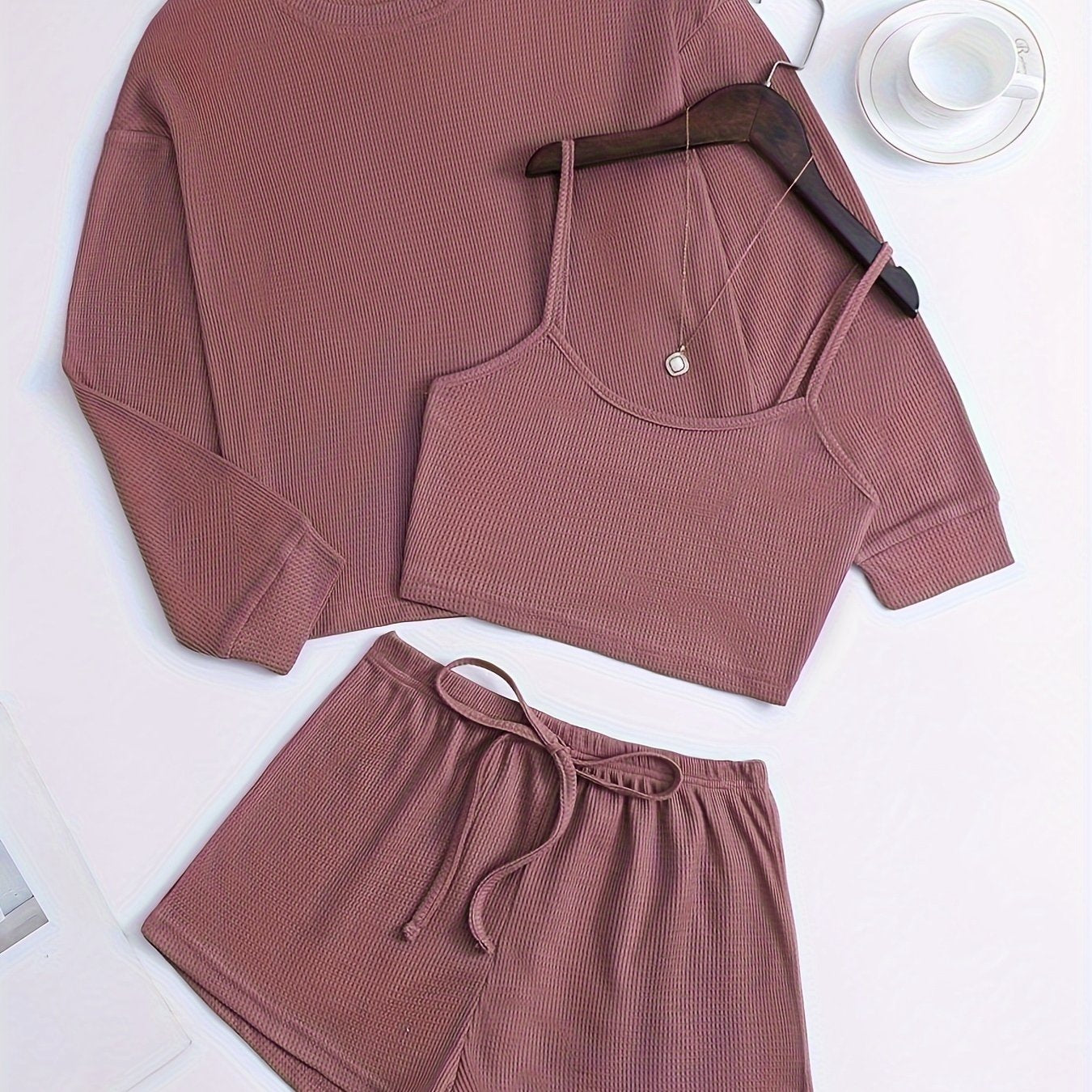 Women's loungewear set with waffle texture, long sleeve top, crop cami, and elastic shorts.