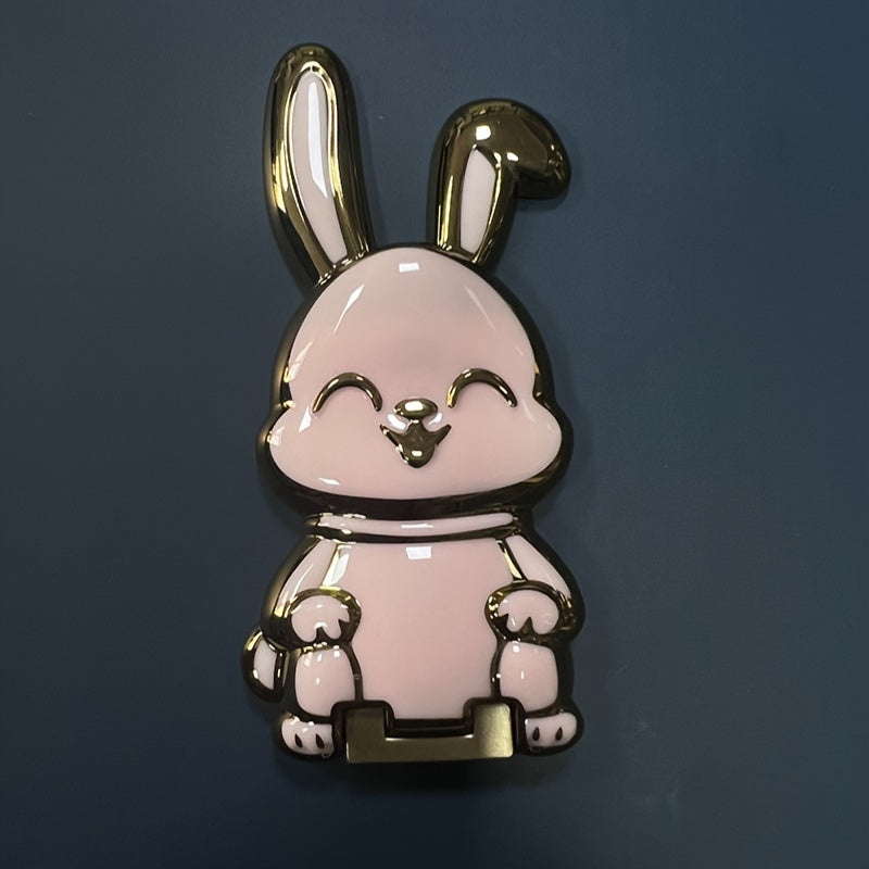 Foldable waterproof phone stand made of ABS material, featuring an adjustable cartoon bunny design for holding smartphones and tablets.