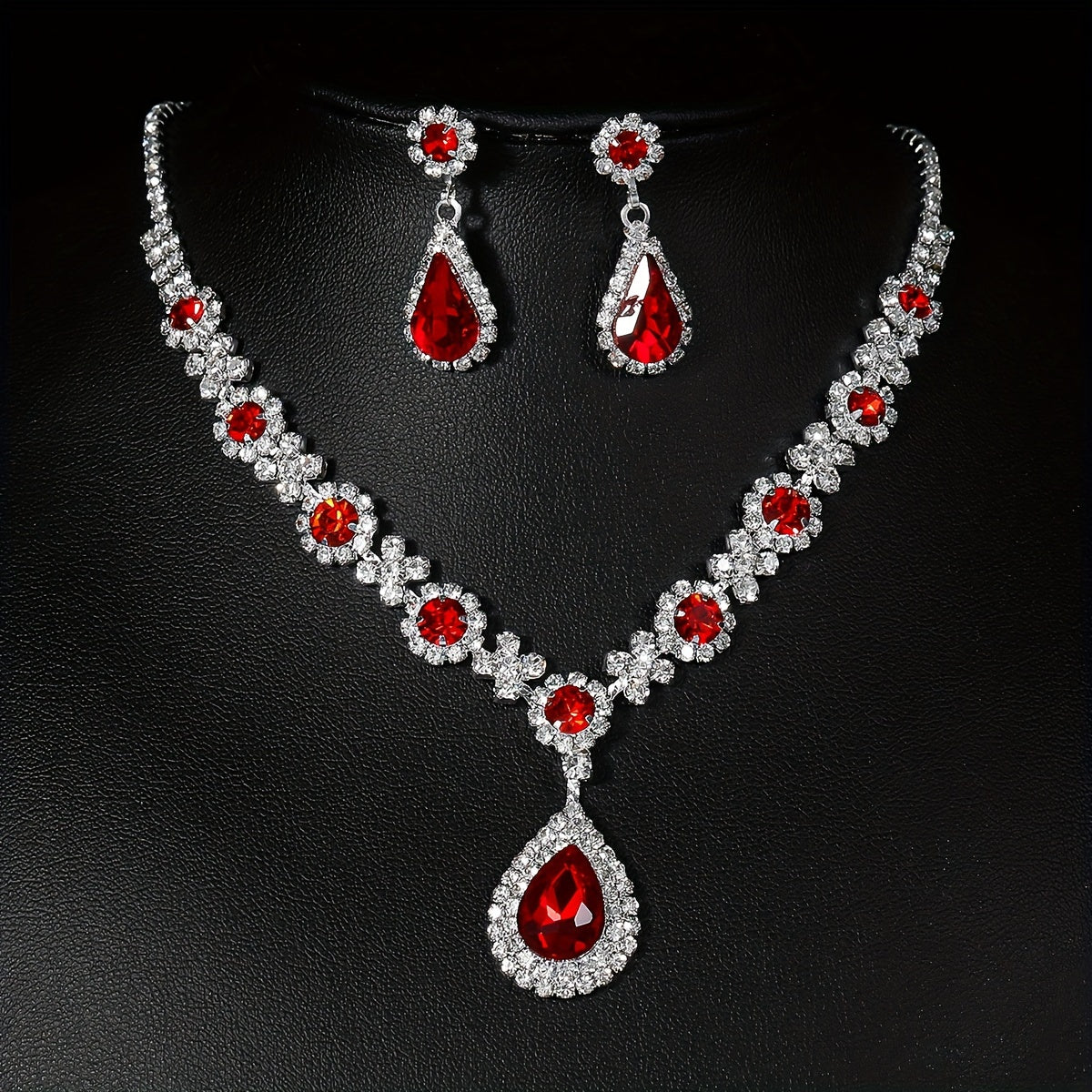 Stylish and opulent silver plated necklace and earrings set adorned with red rhinestone flower detailing and teardrop pendants. This elegant copper fashion jewelry set is designed for women, ideal for parties, banquets, and Valentine's Day. A versatile