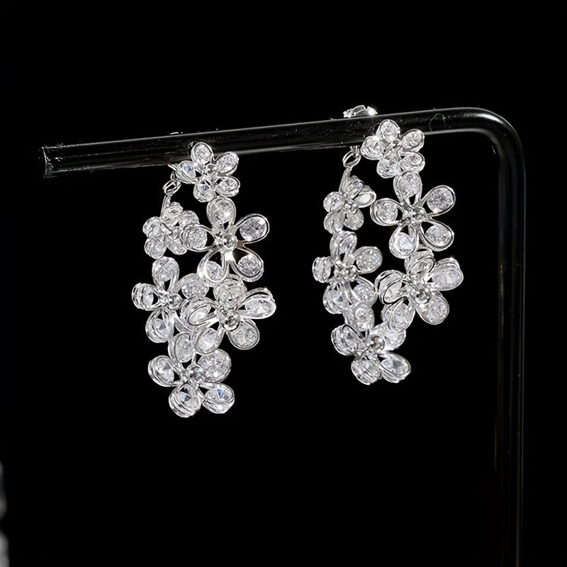 Silvery and elegant, these C-shaped flower hoop earrings are adorned with exquisite details, giving them a bling-bling style that is perfect for any occasion. Made of copper, this versatile piece can be worn as jewelry or used as a stylish ornament.