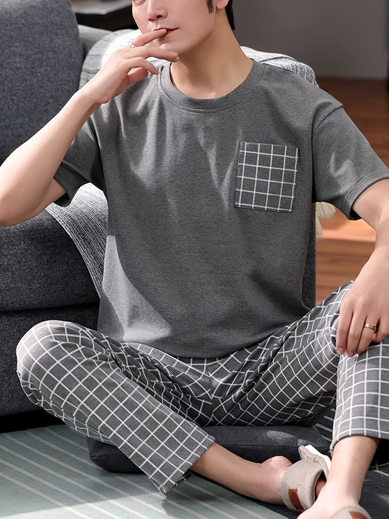 Men's 2-piece plaid pajama set includes round neck top and matching trousers for cozy loungewear comfort.