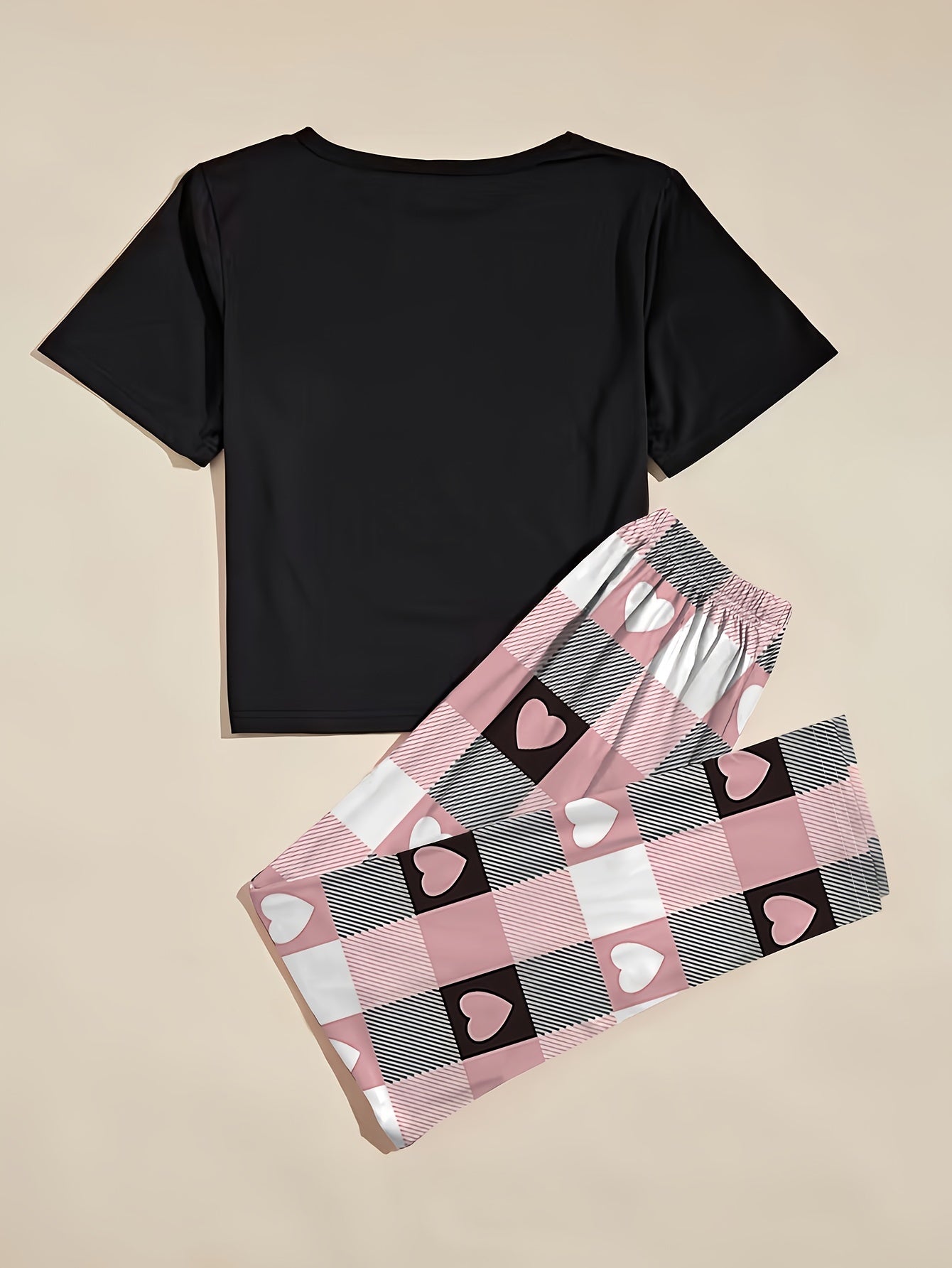 Women's heart graphic t-shirt and plaid pants set in casual polyester knit, featuring a short sleeve top with crew neck and elastic waist lounge pants. Perfect for lounging or sleepwear.