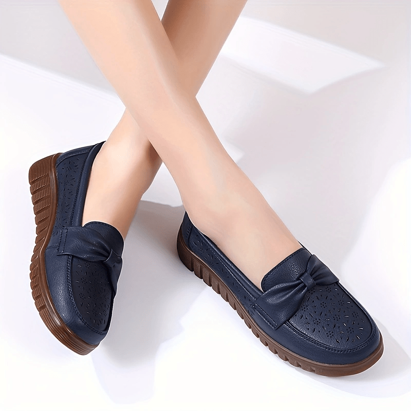 Flat loafers for women with hollow out design, bow detail, soft sole, suitable for casual walking.