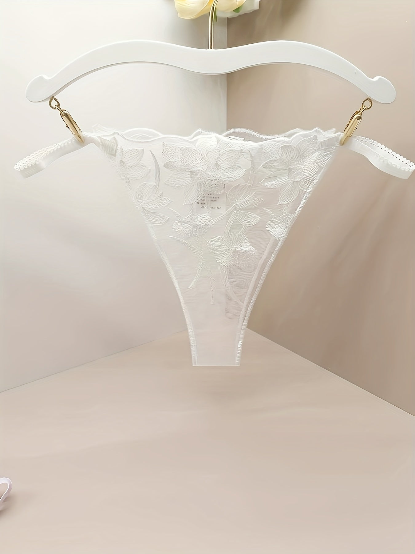 Women's sheer mesh thong panties with embroidered floral design and open crotch, featuring bow detail. Soft and breathable lingerie.