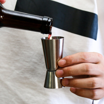 Stainless steel measuring cup, cocktail shaker, and jigger - perfect for bartending and kitchen use.