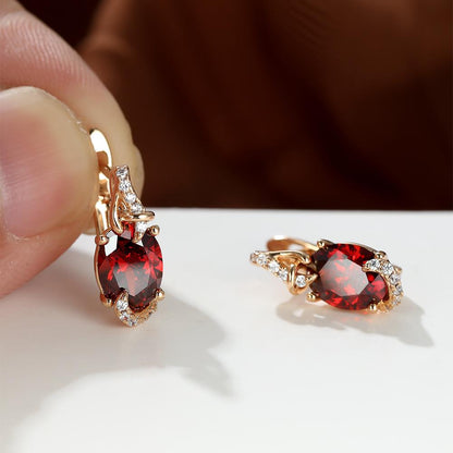 Trendy women's earrings featuring blue, white, red, and pink stones in round and oval cuts. These anniversary claw earrings are plated with 18K gold. Perfect for adding a pop of color to any outfit.