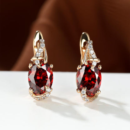 Trendy women's earrings featuring blue, white, red, and pink stones in round and oval cuts. These anniversary claw earrings are plated with 18K gold. Perfect for adding a pop of color to any outfit.