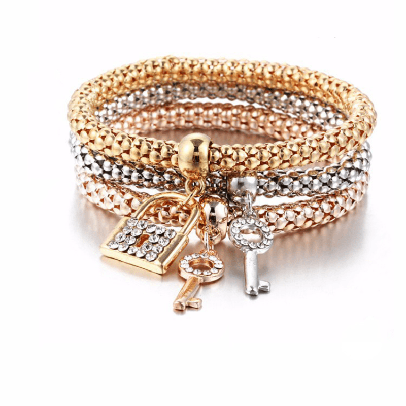 Luxurious stackable bracelet set features three pieces, adorned with elegant plastic mosaic and lock & key pendant. Made from alloy, this stretch jewelry is perfect for daily wear or parties. The elegant charms and luxurious style add a touch of