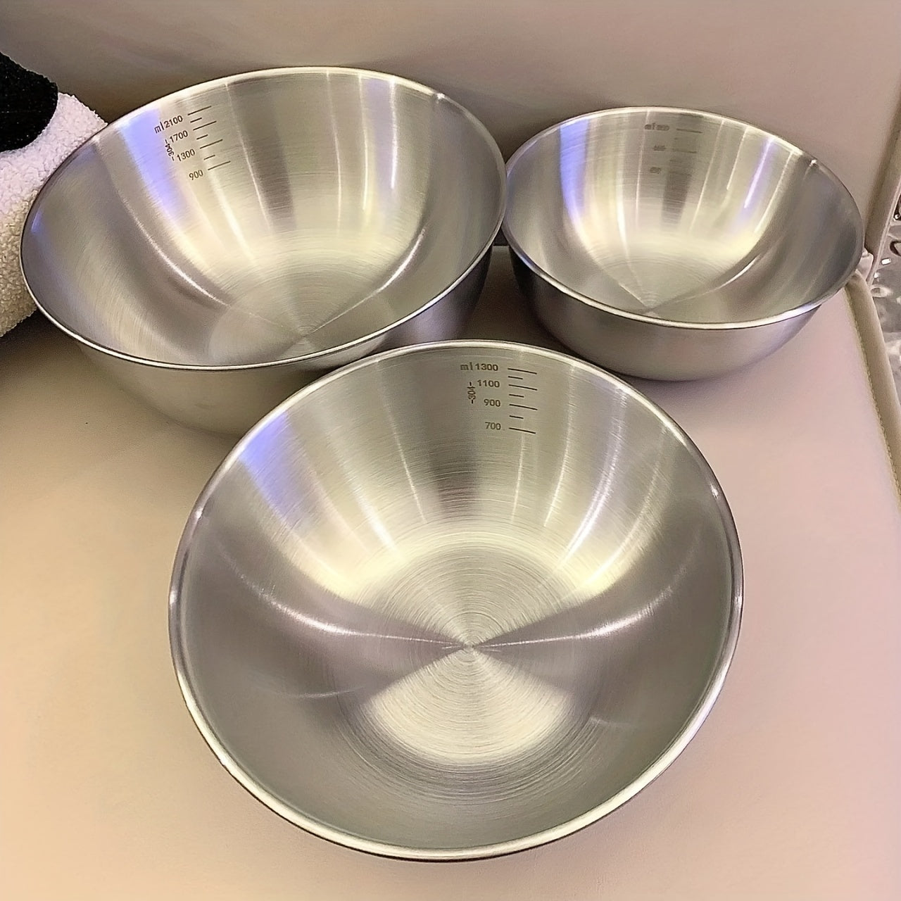 Set of 3 durable stainless steel mixing bowls for easy kitchen prep and storage.