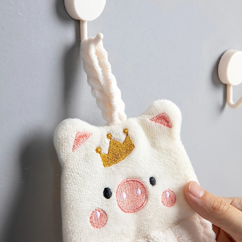 2 cute piggy hand towels made of super absorbent coral velvet with crown design. Includes hanging suction cups for easy display. Fun and whimsical bathroom or kitchen decor.