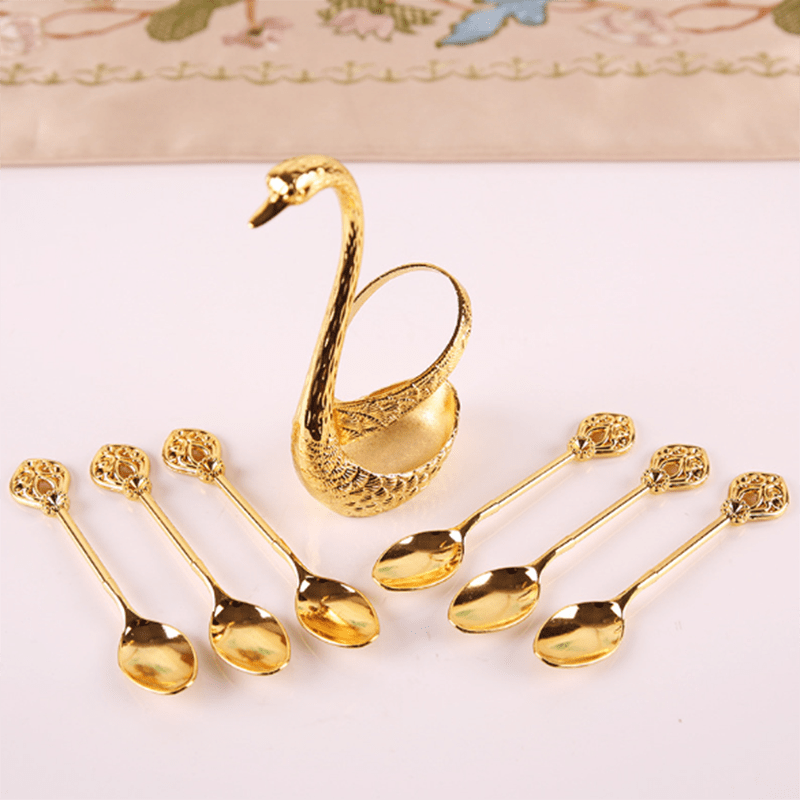 Dinnerware set with swan base stand, spoons for stirring coffee and fruit desserts.