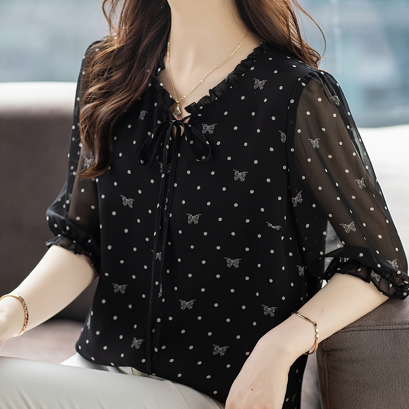 Stylish black floral chiffon blouse with bow tie neckline, sheer sleeves, and non-stretch polyester fabric. Recommended for hand or dry clean only. Ideal for summer 2024.