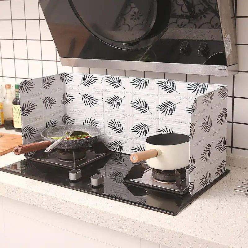 Kitchen stove baffle made of foldable aluminum foil featuring a tropical leaf pattern. This splash guard and cooking safety screen is perfect for deep frying and adding a touch of style to your kitchen decor. Use it as stove top protectors for added