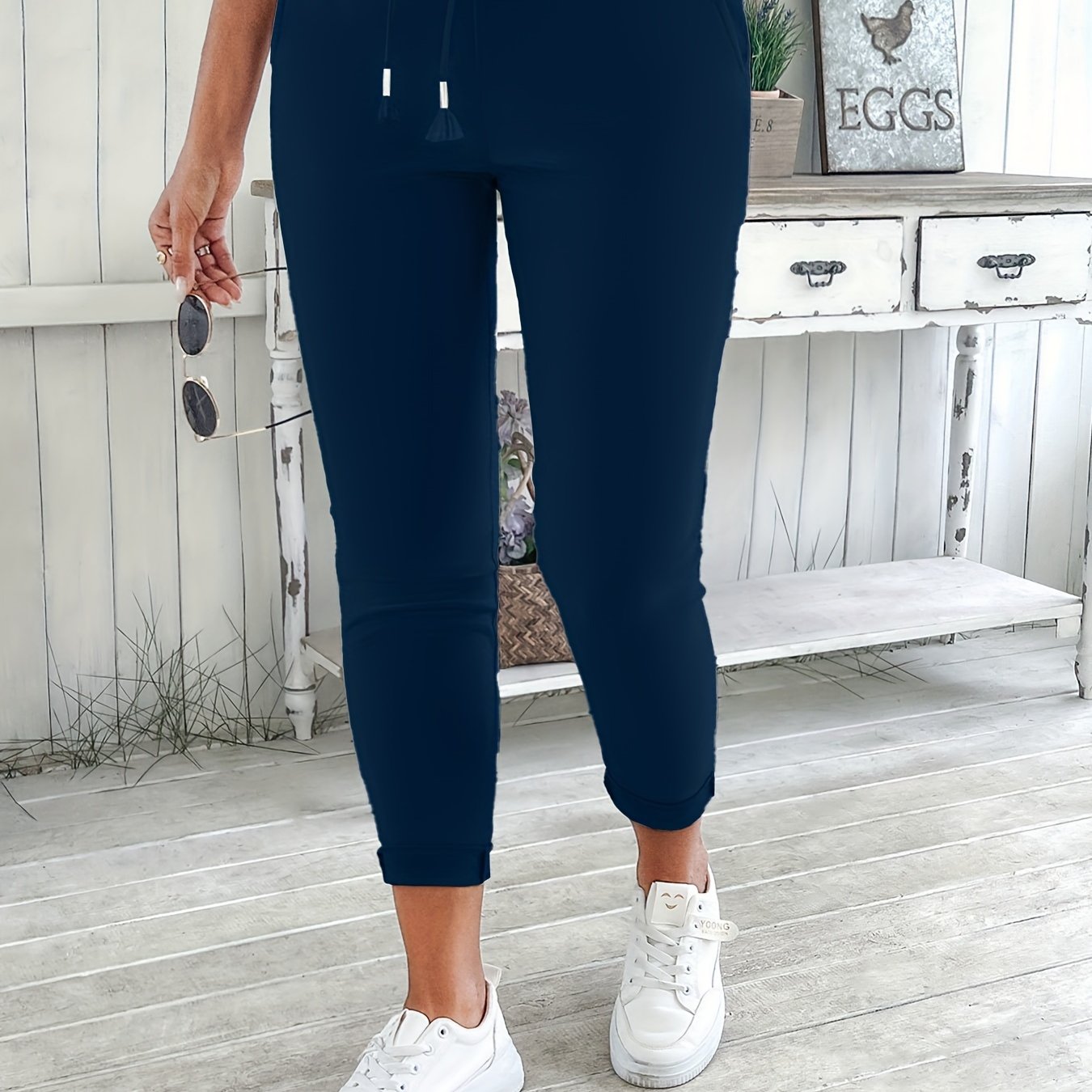 Navy blue drawstring jogger pants for women. Made of stretchy polyester with pockets. Machine washable. Comfortable and adjustable, perfect for all seasons.