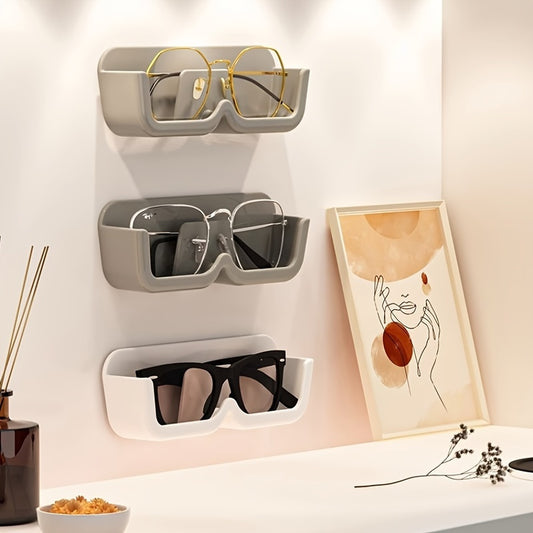 Wall-mounted eyeglass storage rack made of plastic. Can also be used for hanging glasses and sunglasses. Helps save space and keep items organized in the home. Can be used as home decor or gifted for Christmas or New Year to men or women.