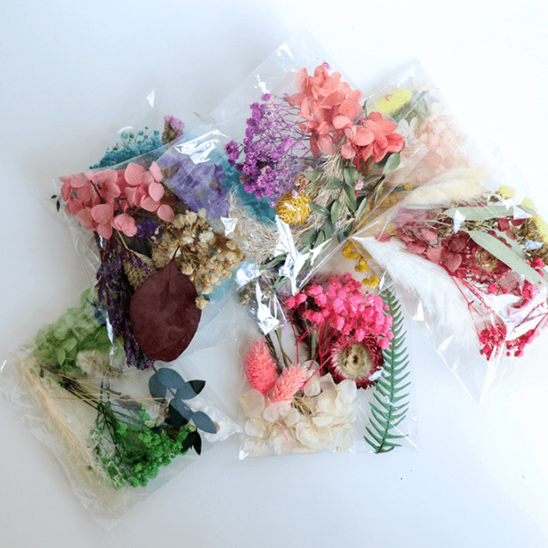 Assorted flowers, preserved materials, and epoxy resin fillers for DIY floral projects.