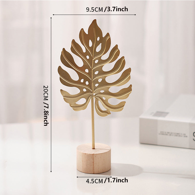 One elegant Nordic-inspired metal art decor featuring iron leaf, snowflake, and palm designs on a wooden base. Perfect for contemporary home and bedroom accents.