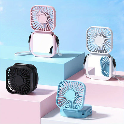 Mini Foldable Desktop Block with Mirror, Multi-functional Handheld Portable Pocket Fan with USB Charging. Can be used as a Hanging Neck Fan or placed on a Desktop. Features Mute Operation and Large Wind Output. Ideal for Creative Desktop Use in the