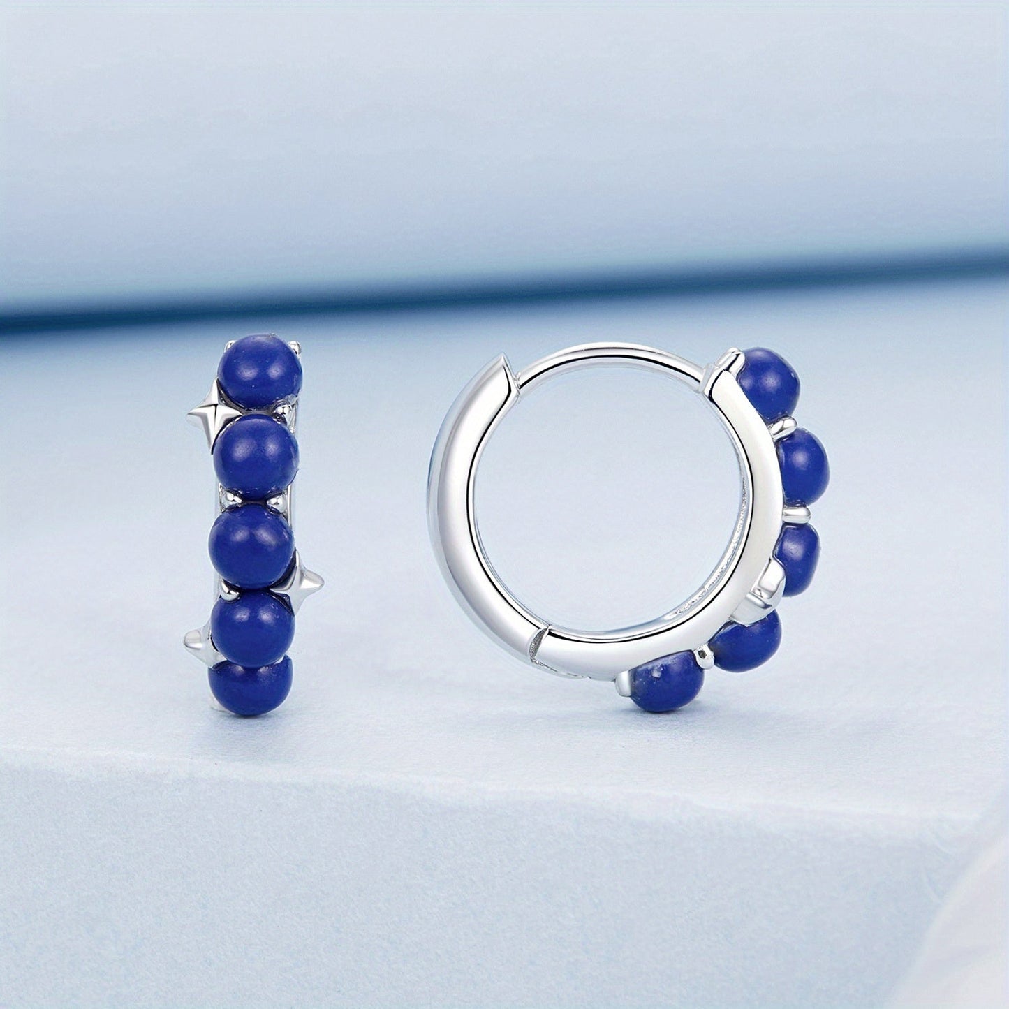 Add a touch of elegance to your outfit with these stylish women's hoop earrings featuring synthetic lapis lazuli beads. Made with 925 sterling silver, these luxurious earrings are perfect for vacations, weddings, casual parties, or as a holiday gift.