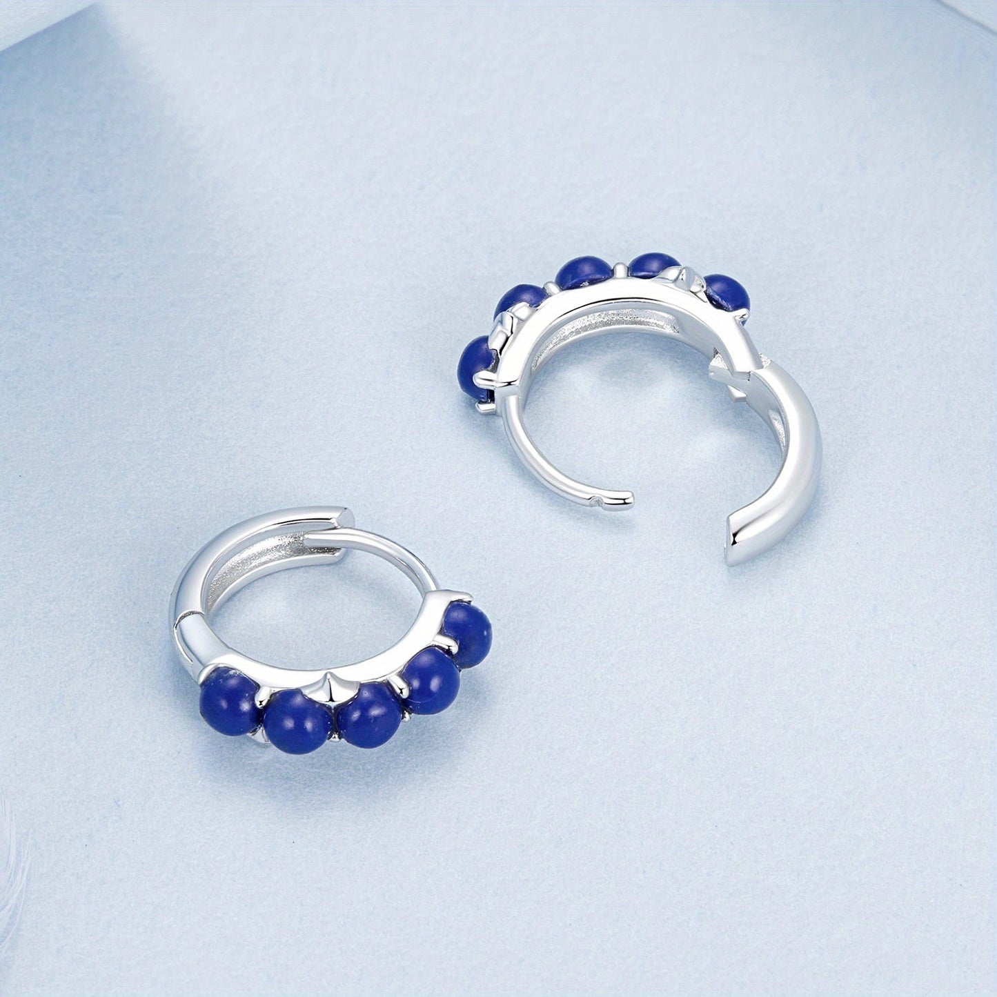 Add a touch of elegance to your outfit with these stylish women's hoop earrings featuring synthetic lapis lazuli beads. Made with 925 sterling silver, these luxurious earrings are perfect for vacations, weddings, casual parties, or as a holiday gift.