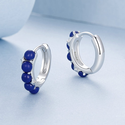 Add a touch of elegance to your outfit with these stylish women's hoop earrings featuring synthetic lapis lazuli beads. Made with 925 sterling silver, these luxurious earrings are perfect for vacations, weddings, casual parties, or as a holiday gift.