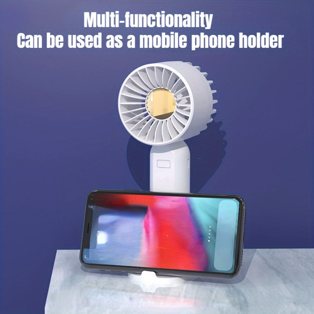 Mini fan with multiple functions - serves as a base and mobile phone holder, features three adjustable wind speeds and can be charged via USB. Perfect for use in the office, outdoors, or while traveling. Handheld and portable design.