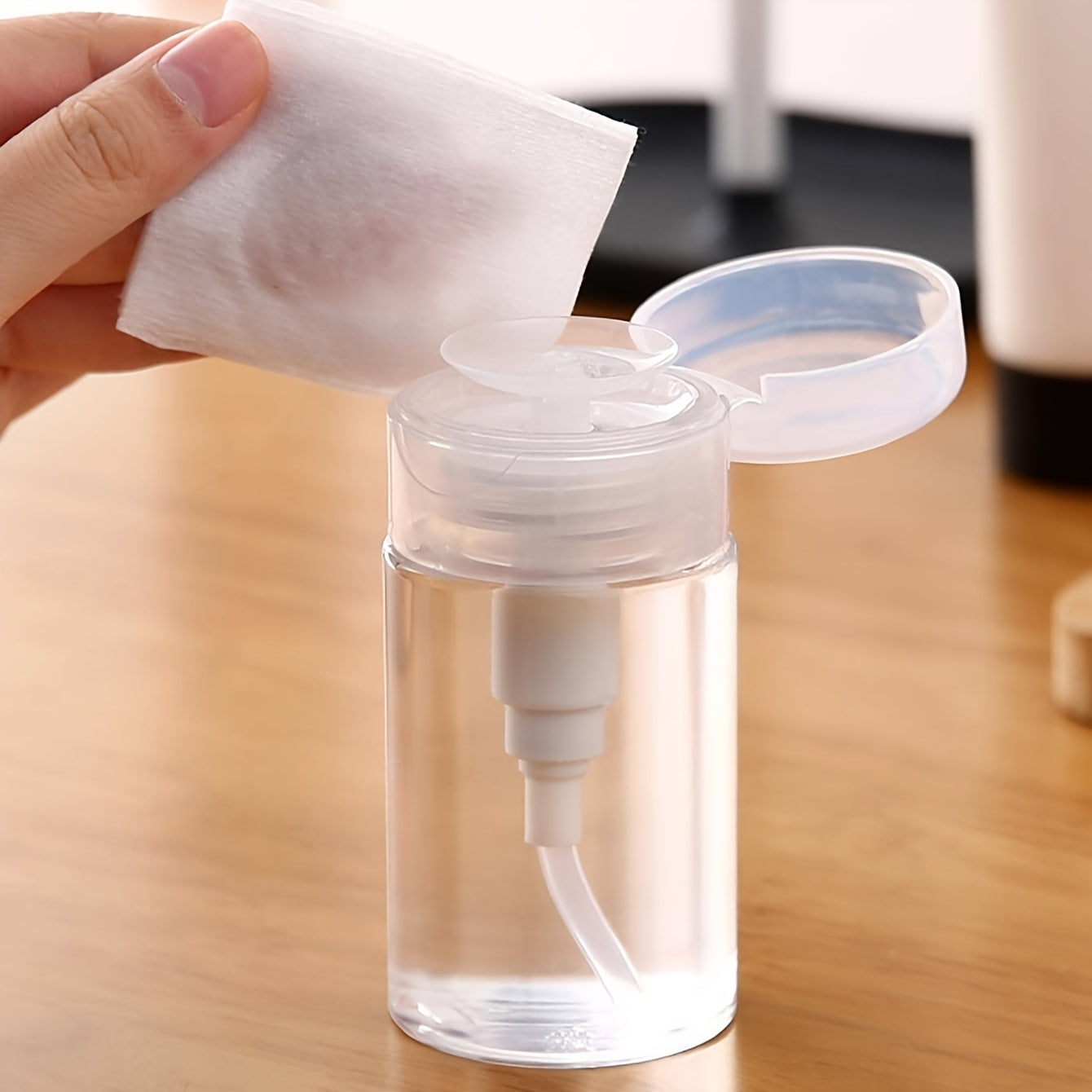 Travel-friendly transparent cosmetic storage box with liquid dispenser for home organization.