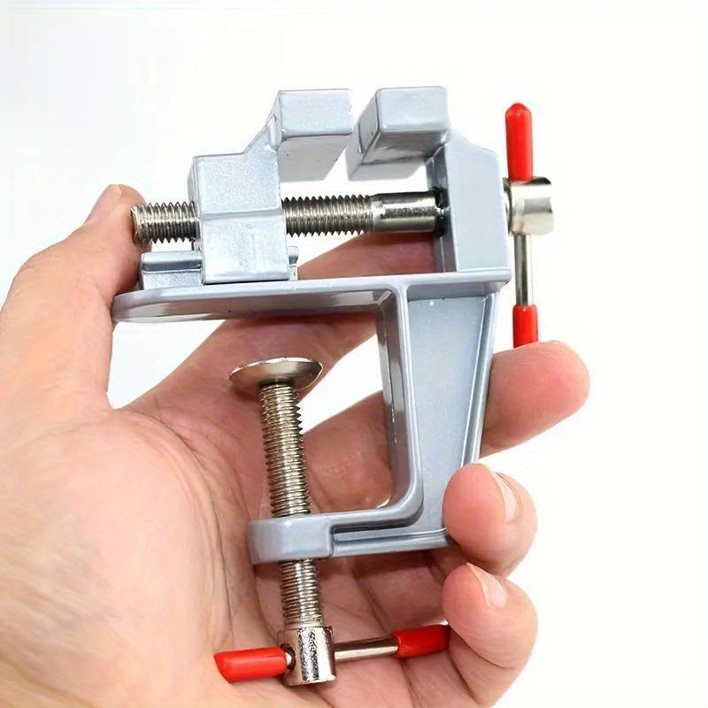 Mini aluminum bench vise with adjustable table clamp for DIY projects.